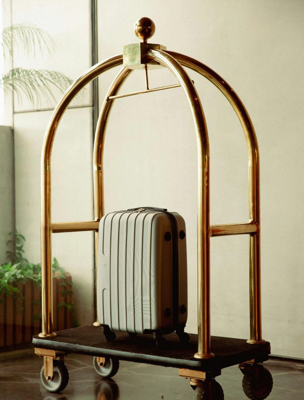 Suitcase on a golden luggage cart.