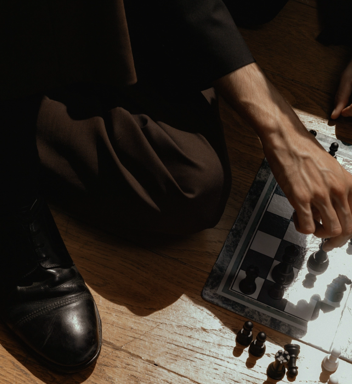 Man sitting on the floor playing chess.